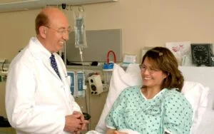 woman in teal scrub suit sitting beside man in white medical scrub suit