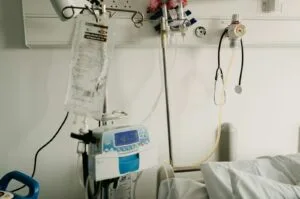 Bedside medical equipment in a home hospital room set up for in-home alcohol withdrawal monitoring.