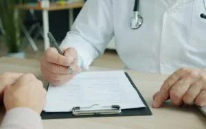 Doctor writing on a patient's chart