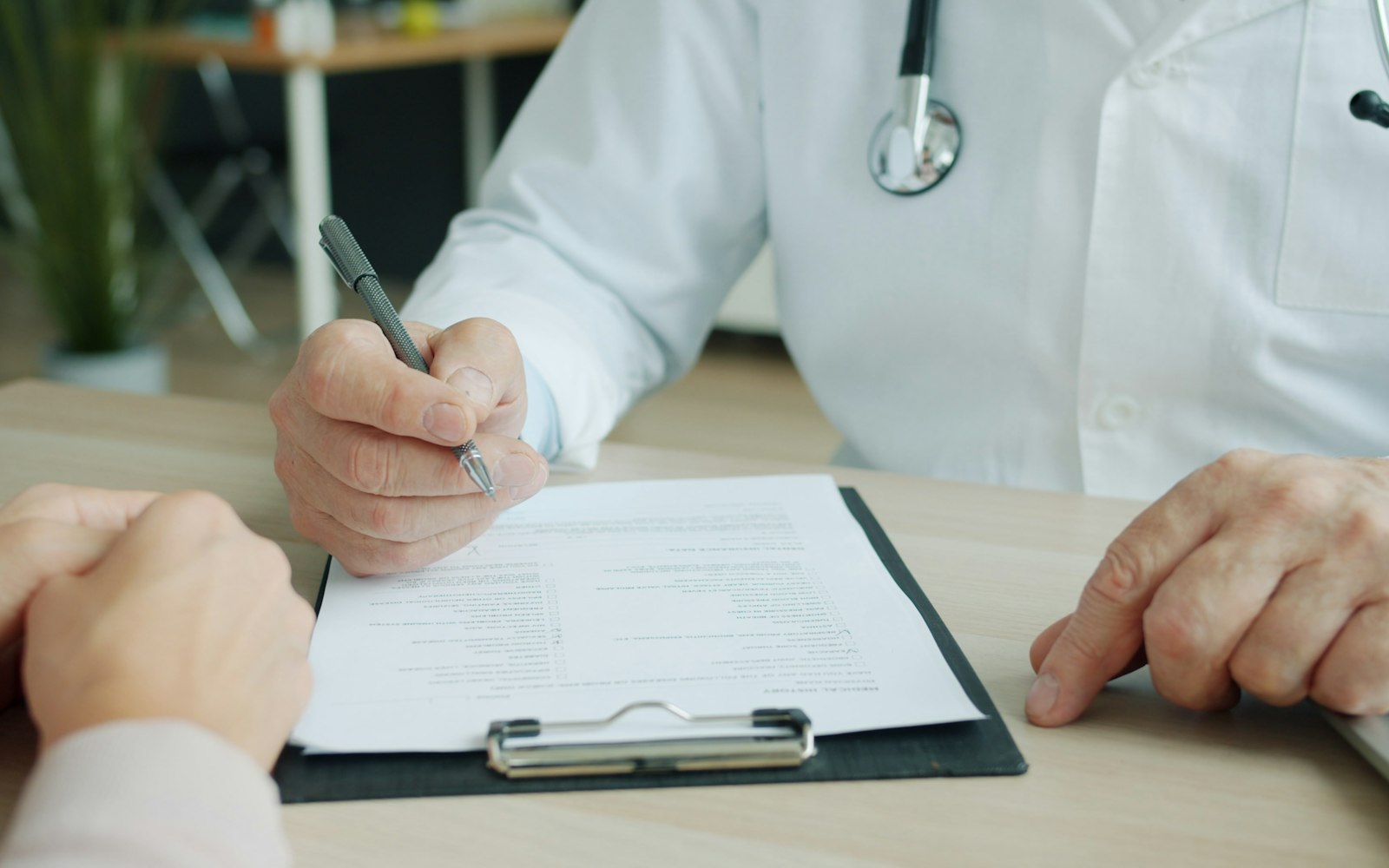 Doctor writing on a patient's chart
