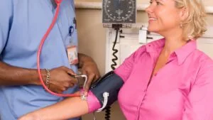 nurse checking a patient blood pressure during an in-home stimulant detox visit